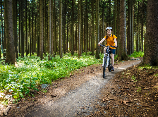 Fietsend meisje op bospad Fietsend meisje op bospad